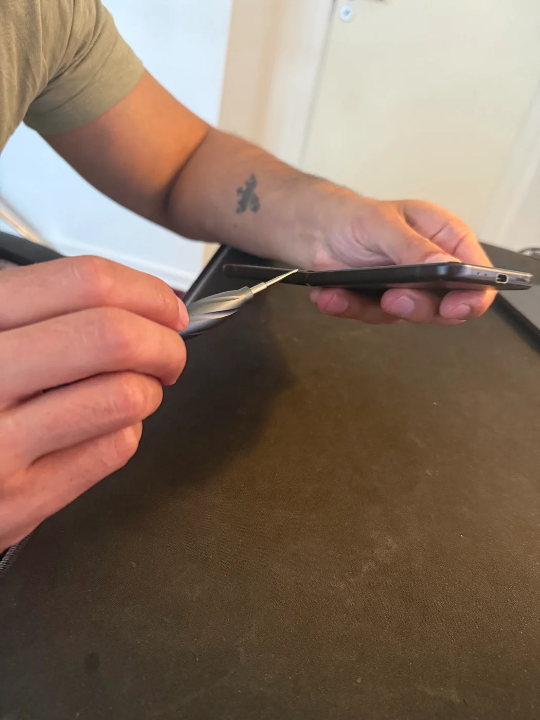 Fonerep-tekniker åbner en telefon med specialværktøj under en reparation